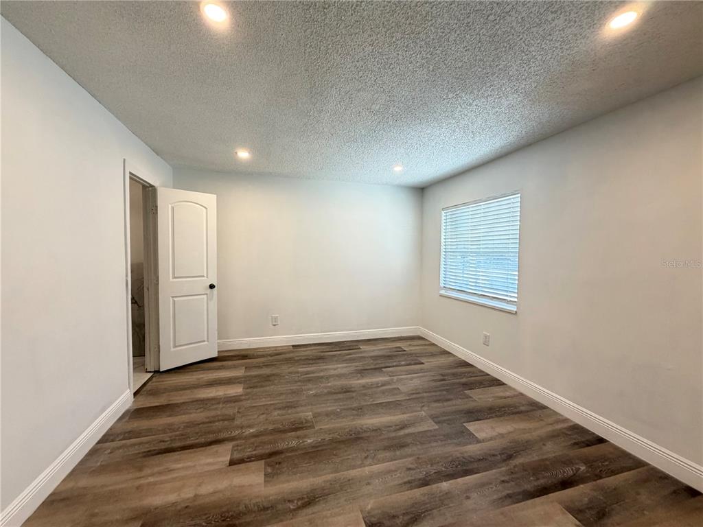3207 Chariot Place Orlando, FL 32818 - Photo 13 of 21 an empty room with wooden floor and windows