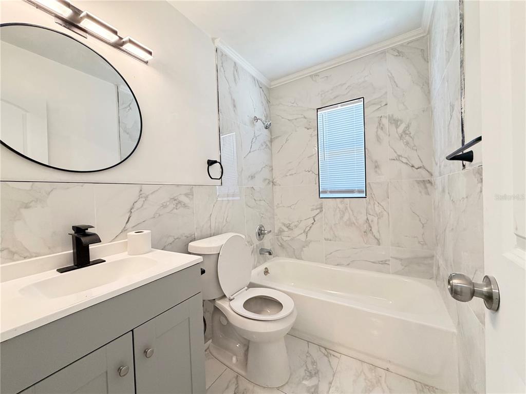 3207 Chariot Place Orlando, FL 32818 - Photo 14 of 21 a bathroom with a sink a toilet and a mirror