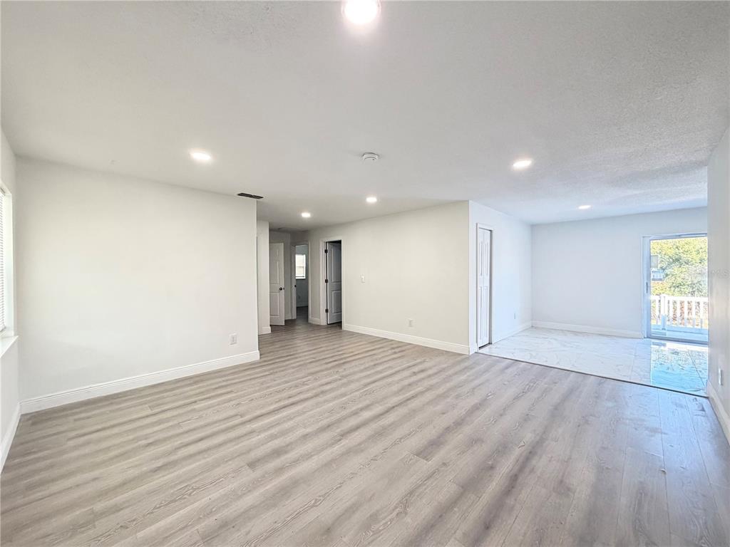 3207 Chariot Place Orlando, FL 32818 - Photo 2 of 21 a view of an empty room with wooden floor and a window