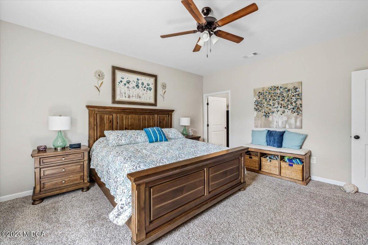 249 Davis Road Gray, GA 31032 - Photo 13 of 53 a bedroom with a bed and a chandelier