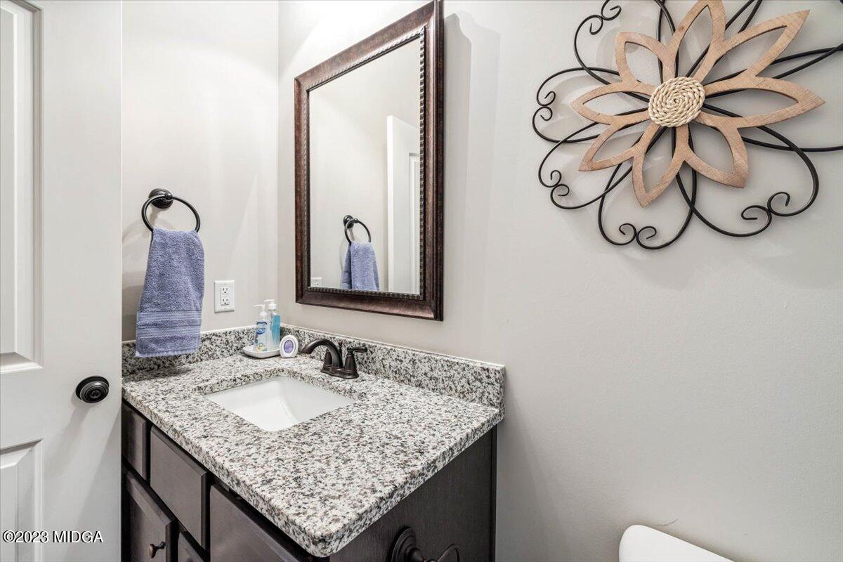 249 Davis Road Gray, GA 31032 - Photo 19 of 53 a bathroom with a granite countertop sink a mirror and a toilet