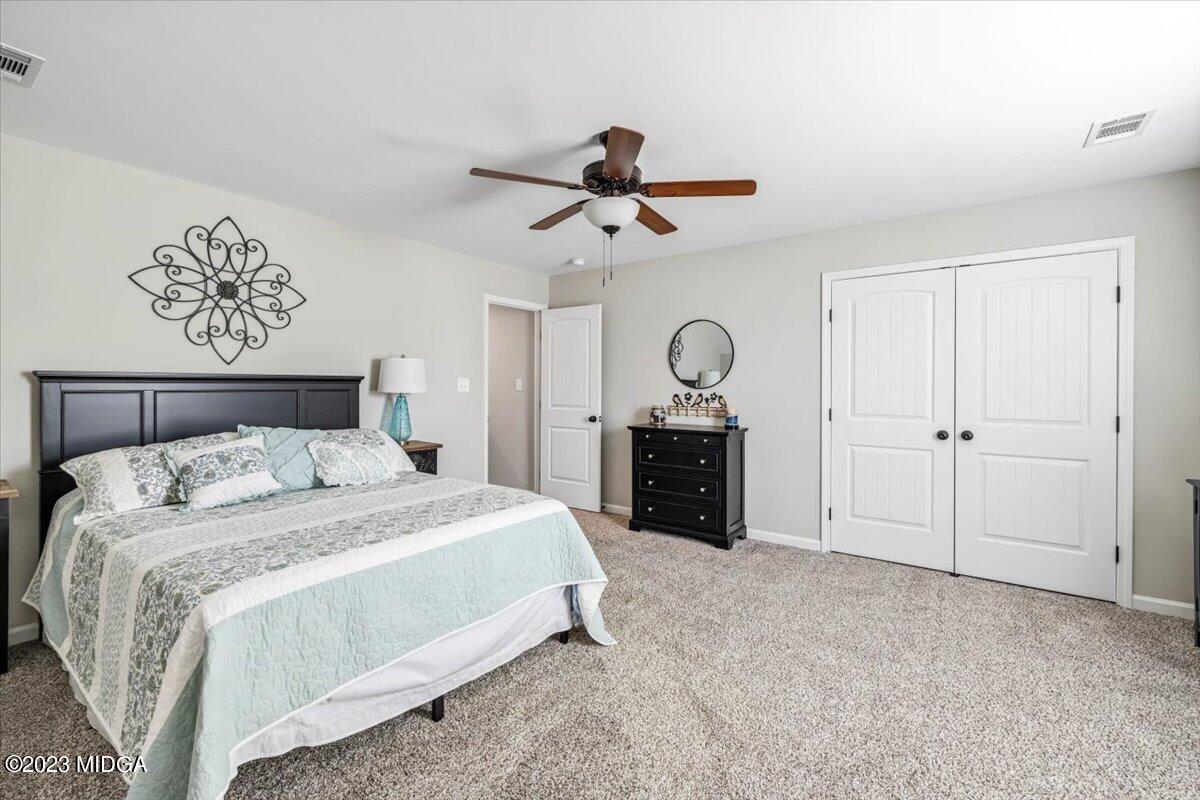 249 Davis Road Gray, GA 31032 - Photo 20 of 53 a spacious bedroom with a bed and cabinets