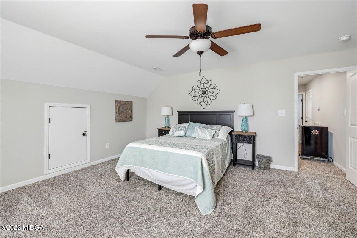 249 Davis Road Gray, GA 31032 - Photo 21 of 53 a spacious bedroom with a bed and a chandelier