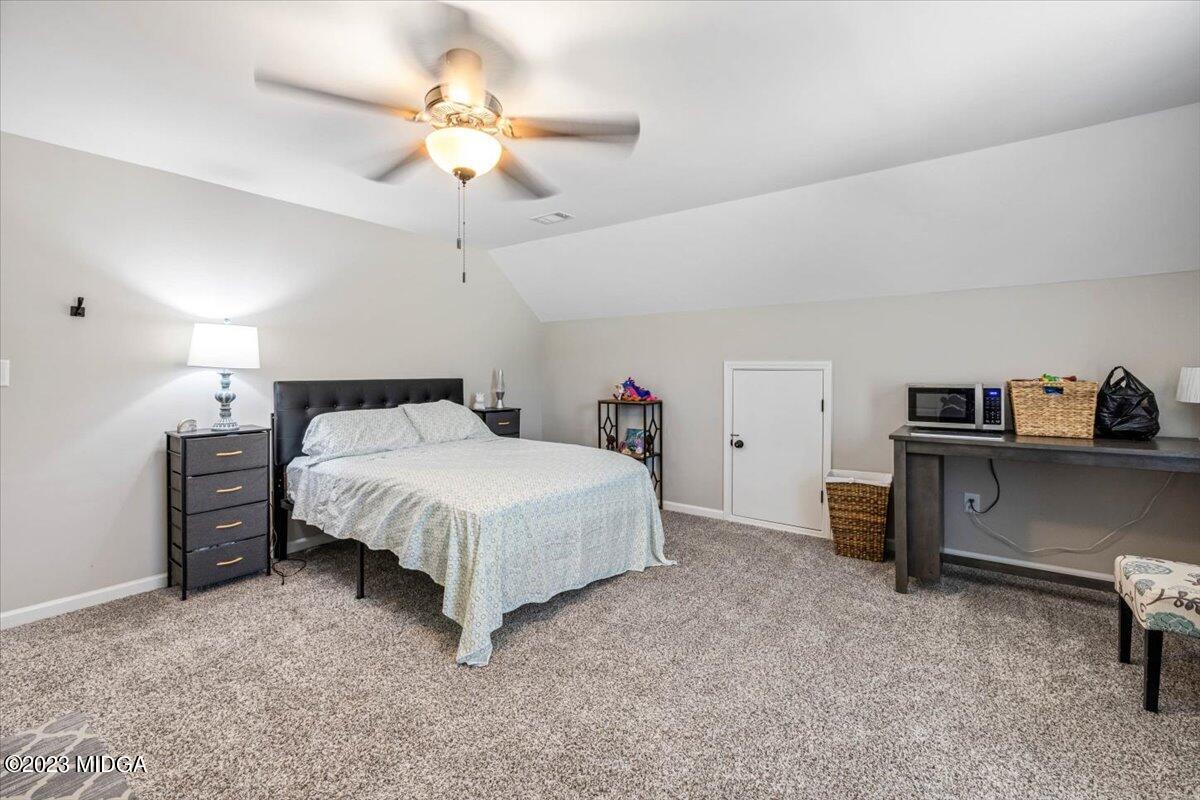 249 Davis Road Gray, GA 31032 - Photo 23 of 53 a bedroom with a bed and a chandelier