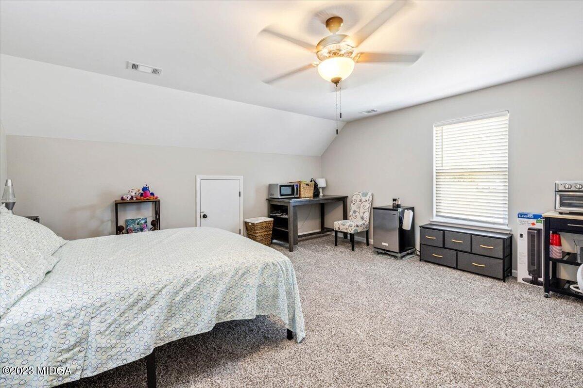 249 Davis Road Gray, GA 31032 - Photo 25 of 53 a bedroom with a bed gym equipment and a chandelier