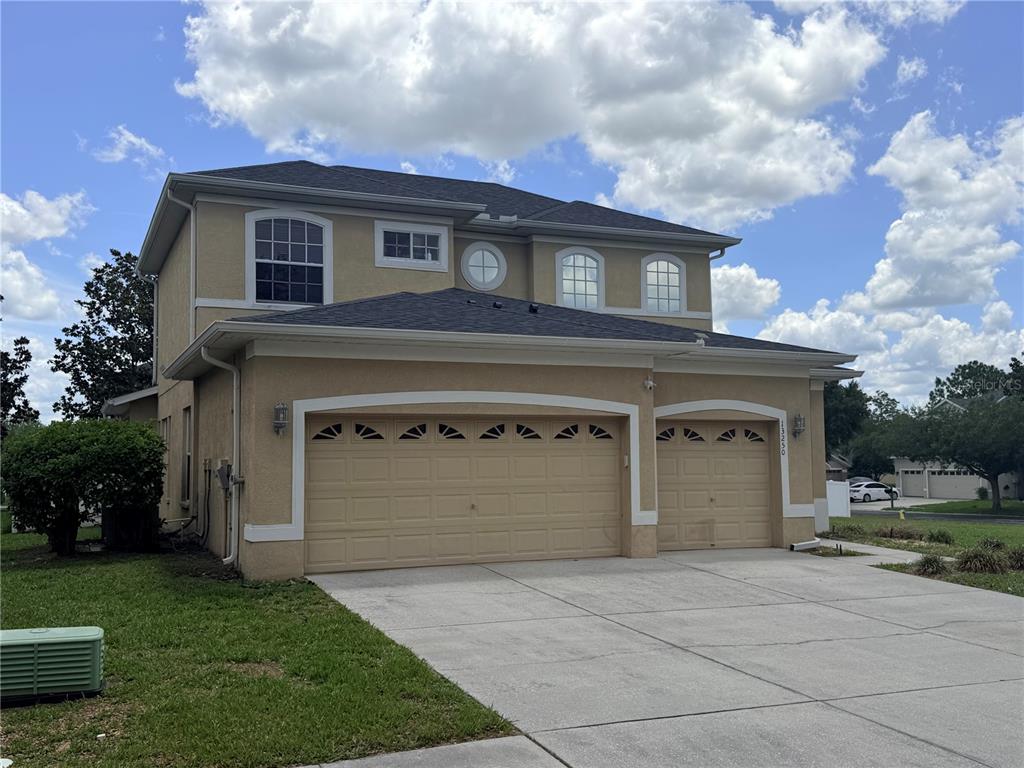 13250 Mandalay Place Spring Hill, FL 34609 - Photo 28 of 28 a front view of a house with a yard and garage