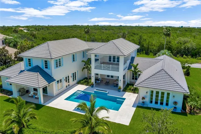 a aerial view of a house with a yard table and chairs