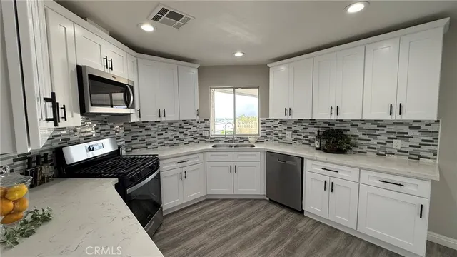 a kitchen with granite countertop a sink stove and cabinets