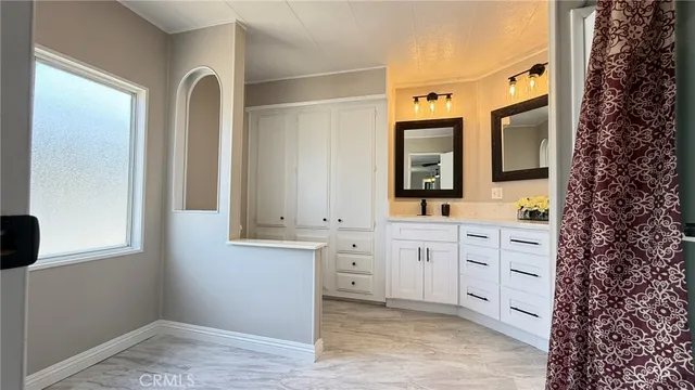 a spacious bathroom with a double vanity sink a mirror and a bathtub