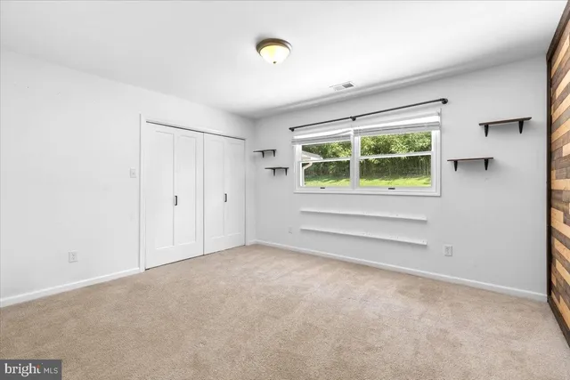 a view of an empty room with cabinet and wooden floor