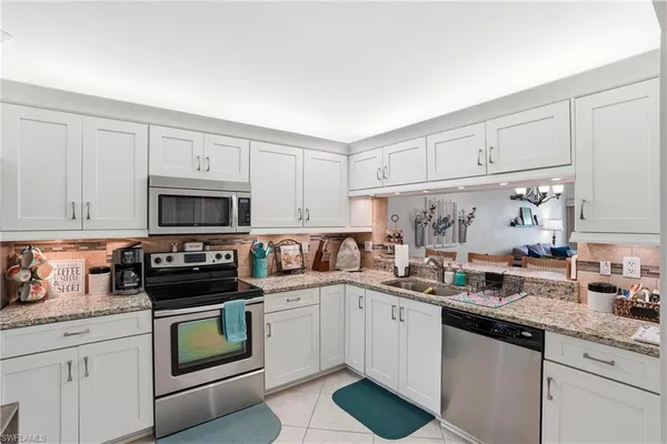 a kitchen with stainless steel appliances granite countertop a sink and cabinets