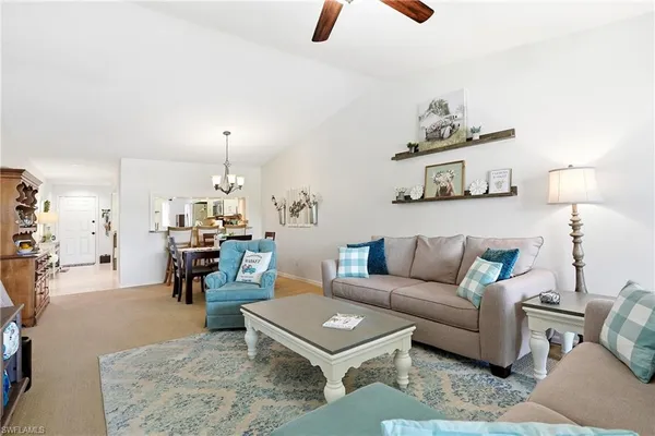 a living room with furniture a rug and a chandelier