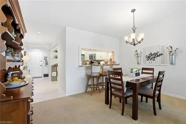 a dining room with furniture a chandelier and window