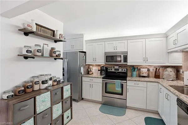 a kitchen with stainless steel appliances granite countertop a refrigerator stove and sink