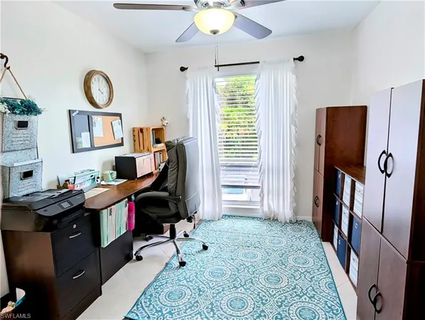 a view of a workspace with furniture and a window
