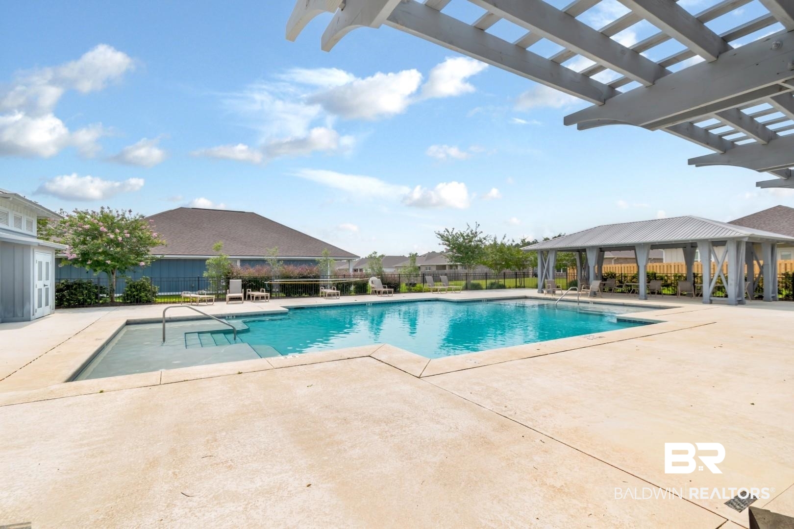 1295 Hayward Loop Foley, AL 36535 - Photo 28 of 29 Outdoor swimming pool with integrated steps, surrounded by a concrete deck, an open-sided gazebo with a metal roof, and a slatted pergola structure
