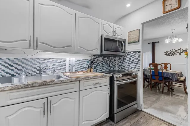 a kitchen with granite countertop cabinets stainless steel appliances and a sink