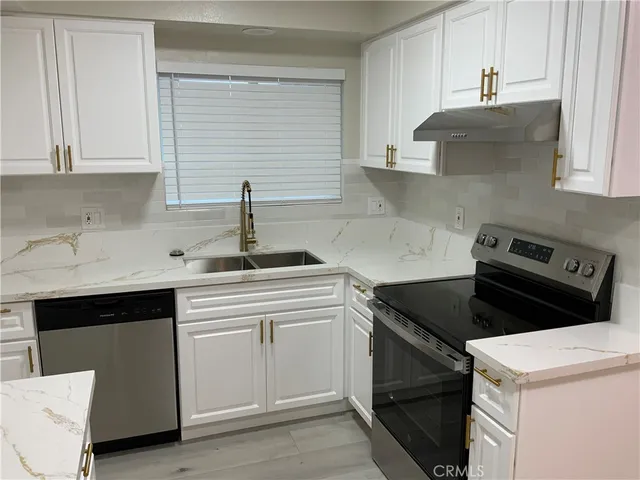 a kitchen with white cabinets and a stove top oven