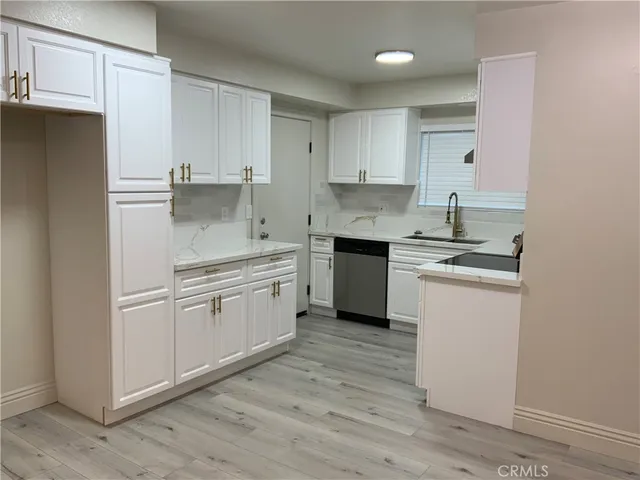 a kitchen with white cabinets and white appliances