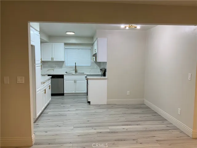 a kitchen with a sink cabinets and wooden floor