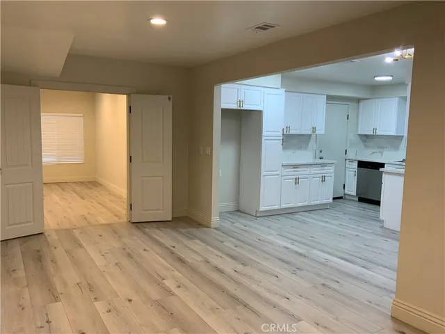 a view of a kitchen with wooden floor and a sink