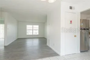 a view of a hallway with wooden floor and closet