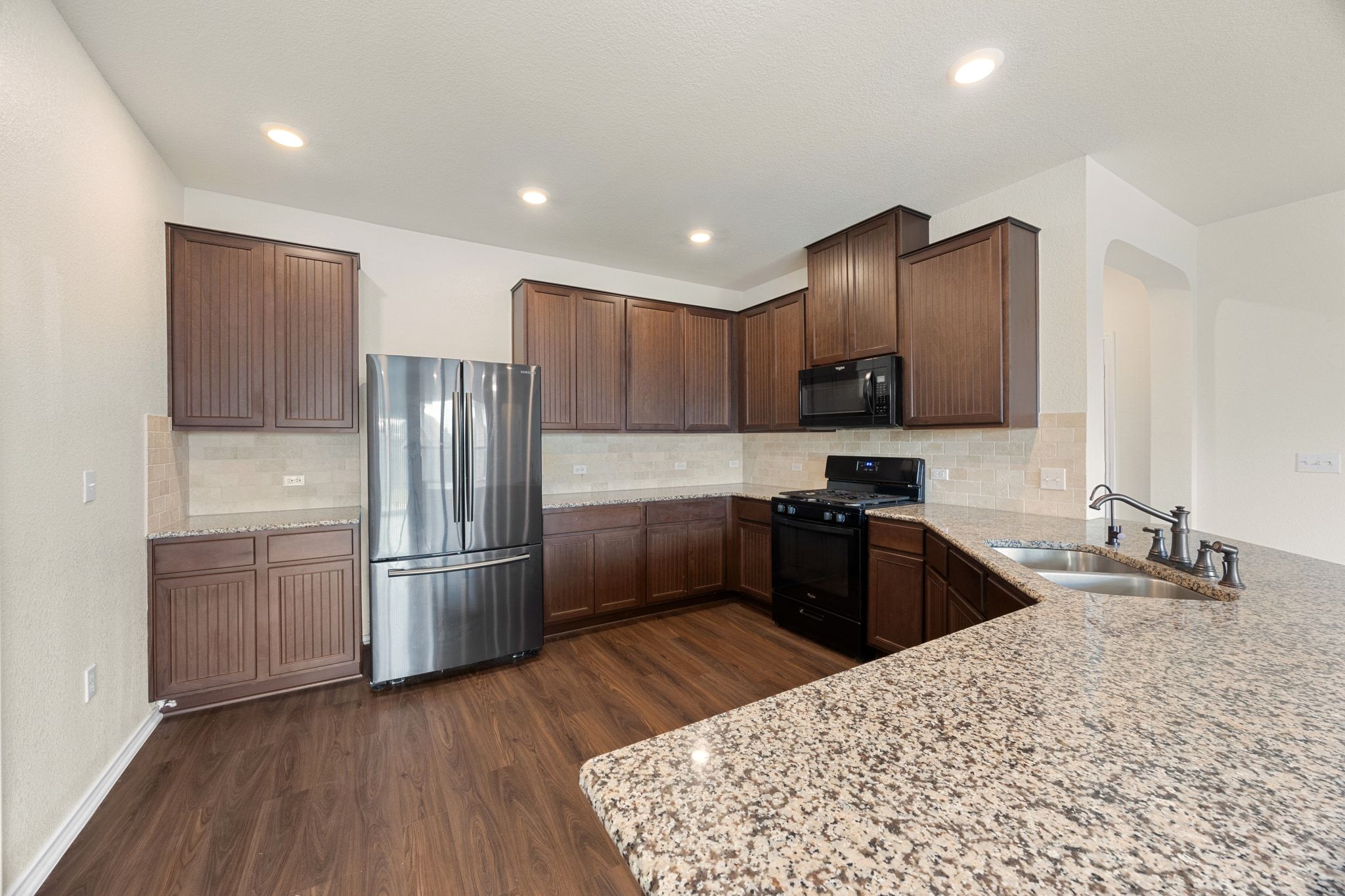 136 Vickers Street Georgetown, TX 78628 - Photo 11 of 33 a kitchen with granite countertop stainless steel appliances and wooden cabinets