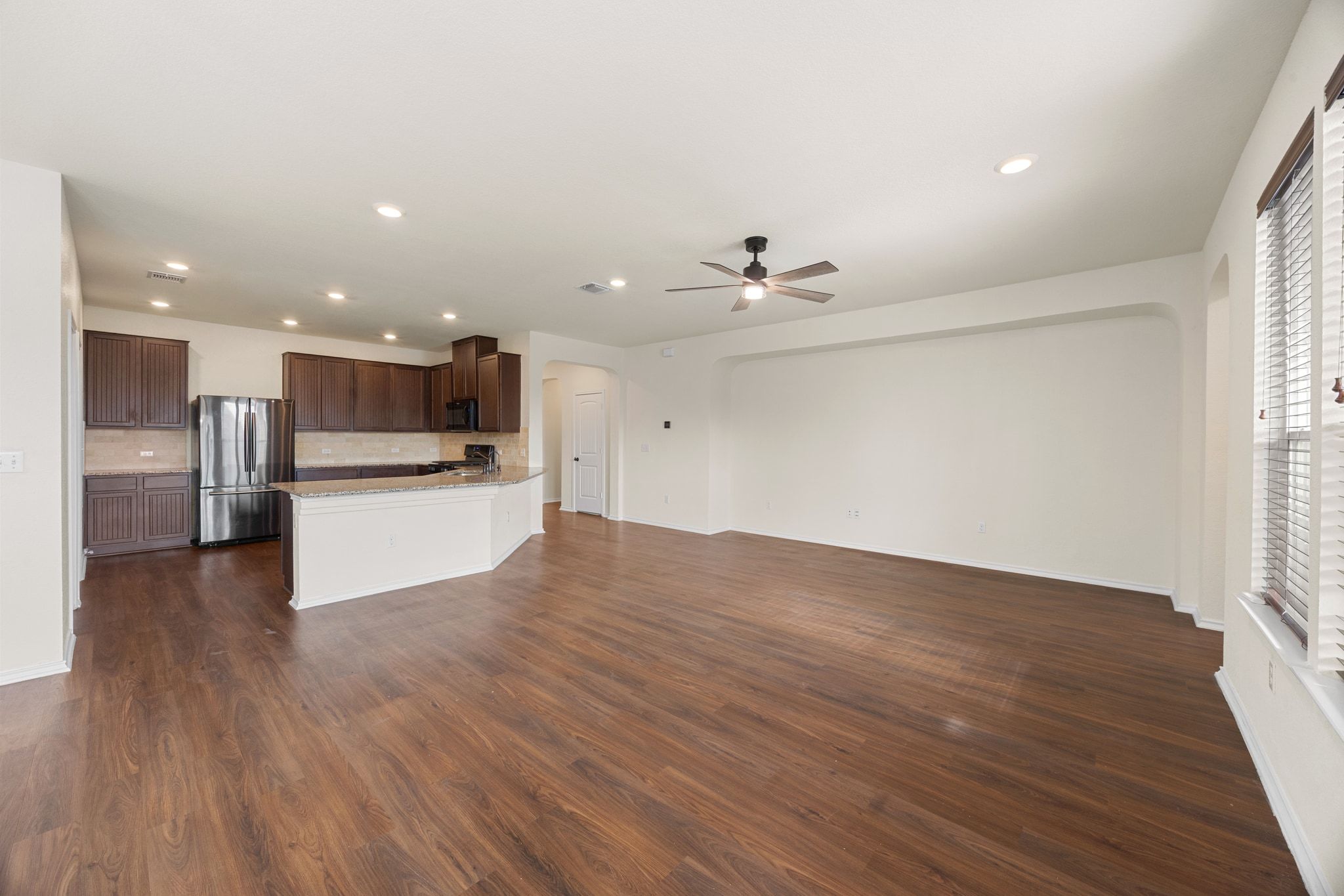 136 Vickers Street Georgetown, TX 78628 - Photo 33 of 33 Kitchen featuring open floor plan, freestanding refrigerator, recessed lighting, dark brown cabinets, and a peninsula