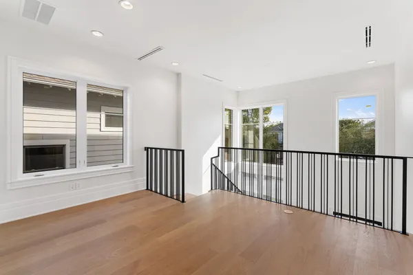 a view of a room with wooden floor and windows