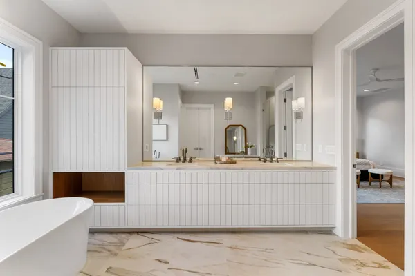 a spacious bathroom with a double vanity sink a mirror and a bathtub