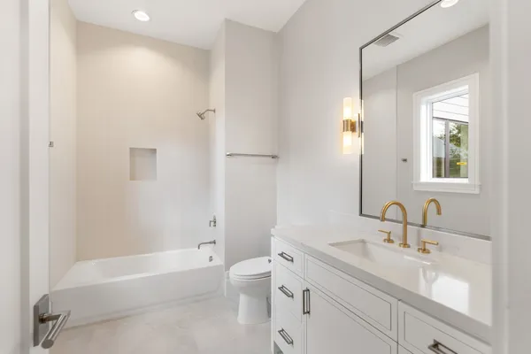 an empty room with wooden floor and natural light