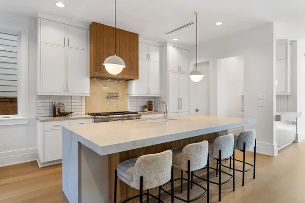 a kitchen with a dining table chairs sink and cabinets