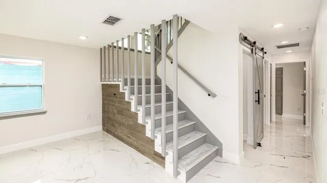 a view of staircase with white walls and windows