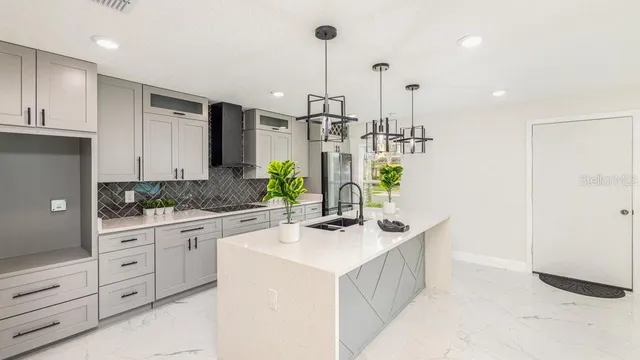 a kitchen with kitchen island sink stove and cabinets