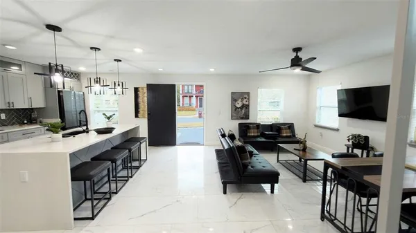 a large kitchen with a table chairs refrigerator and a sink