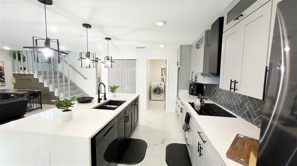 a kitchen with a sink a kitchen island a stove and a wooden floors