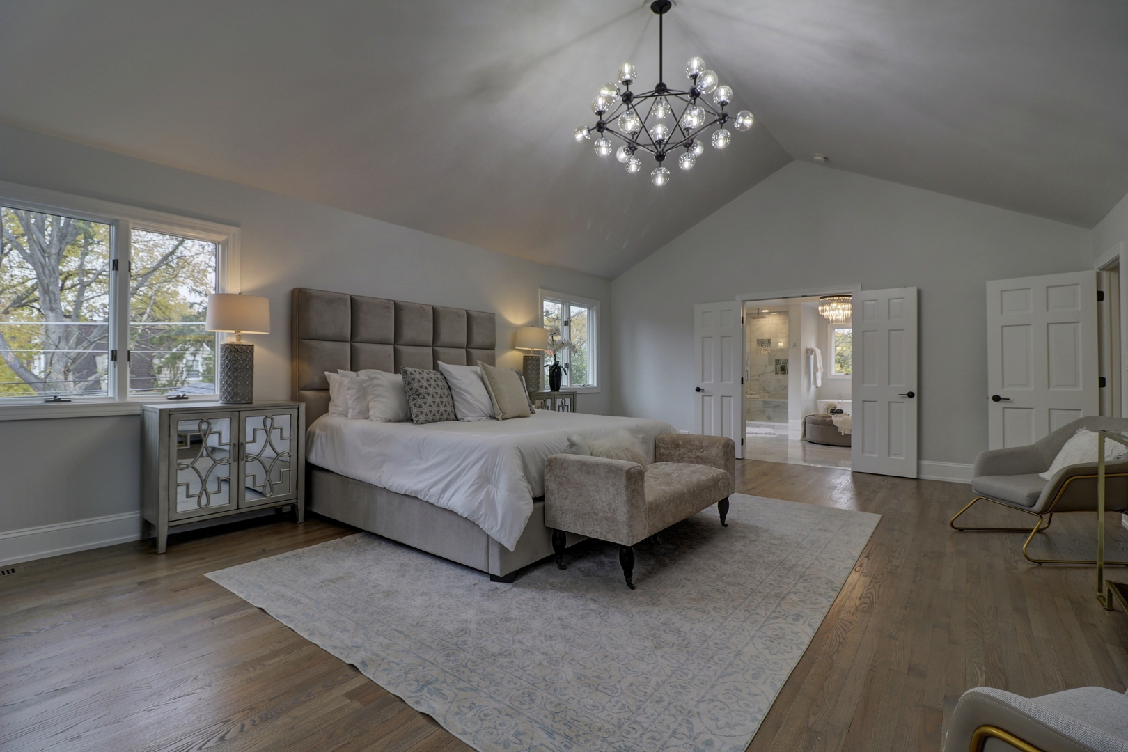 3910 Wolf Road Western Springs, IL 60558 - Photo 22 of 36 a spacious bedroom with a bed a chandelier and window