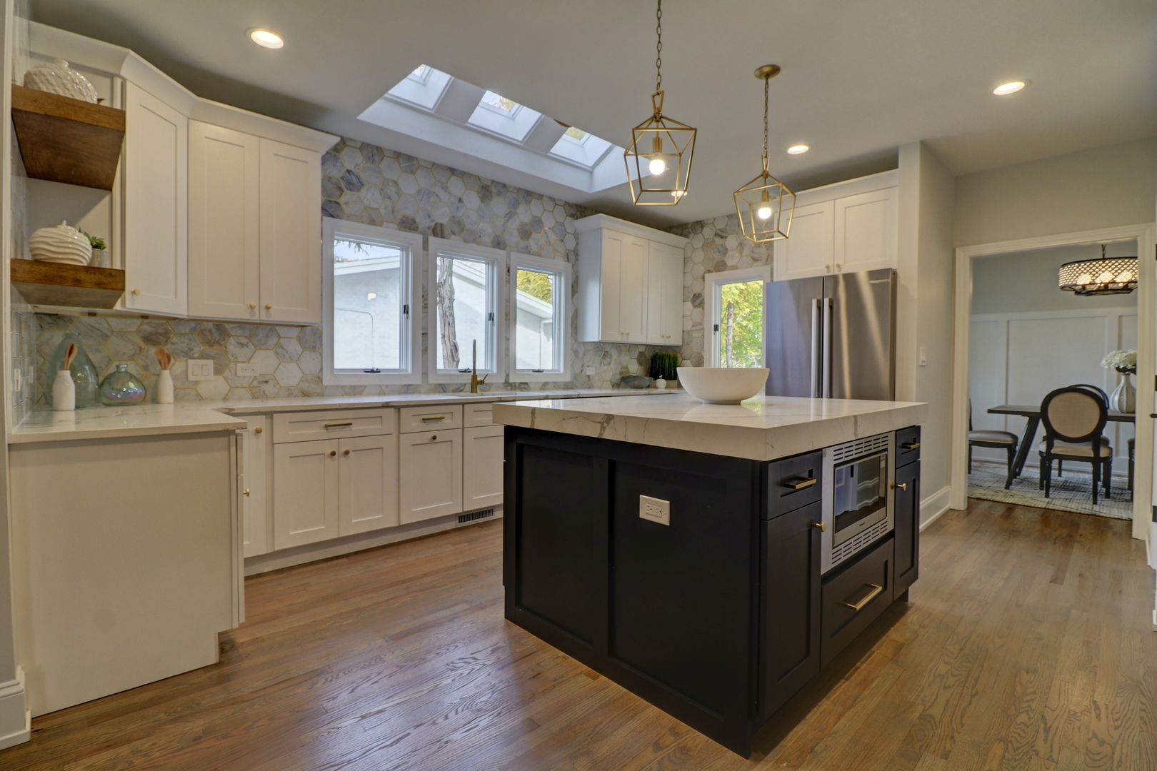 3910 Wolf Road Western Springs, IL 60558 - Photo 5 of 36 a kitchen with kitchen island granite countertop a sink cabinets and wooden floor