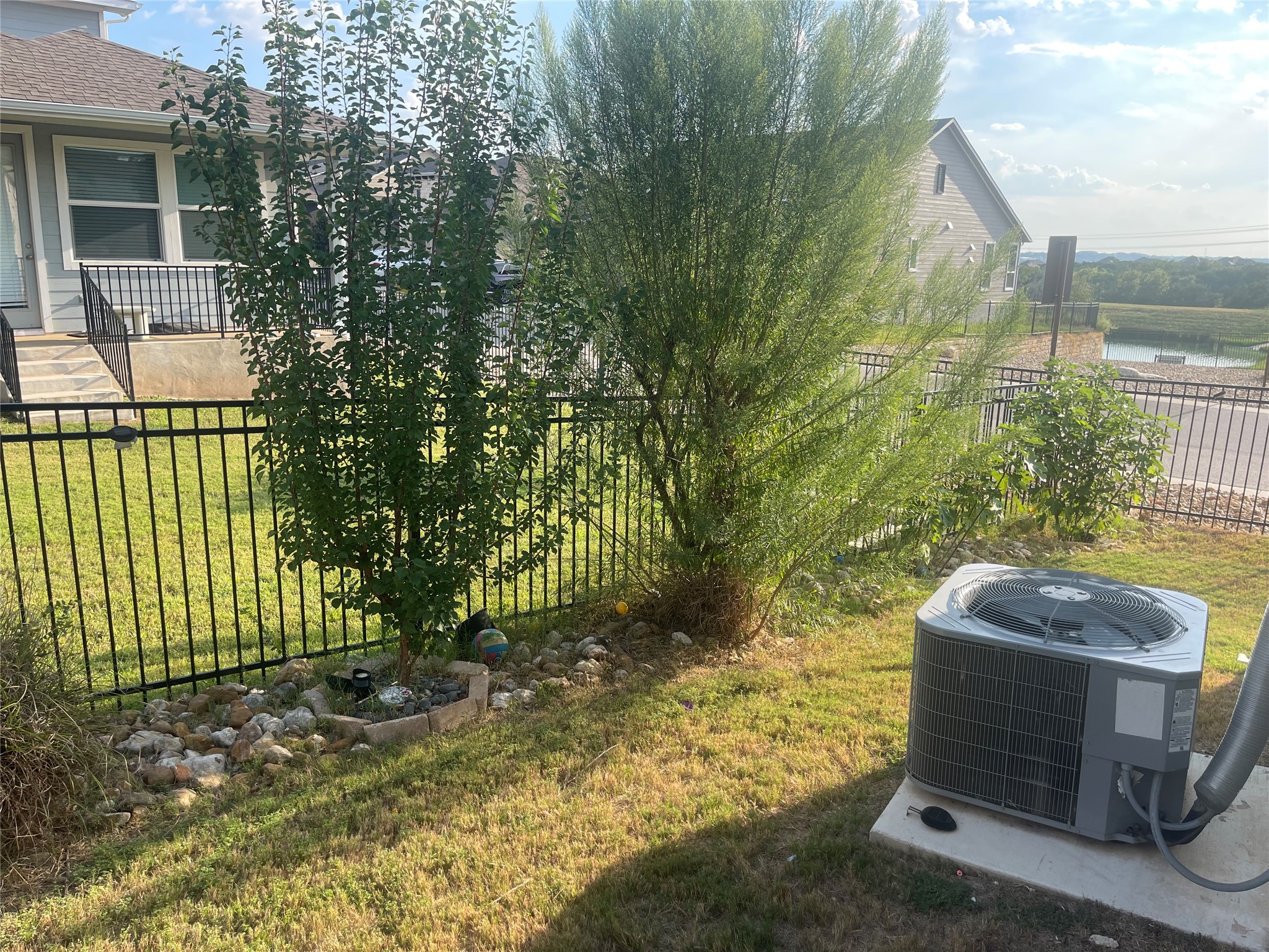 145 Merrick Road Georgetown, TX 78628 - Photo 27 of 32 A fenced backyard offers neat stone border landscaping along with a distant view.