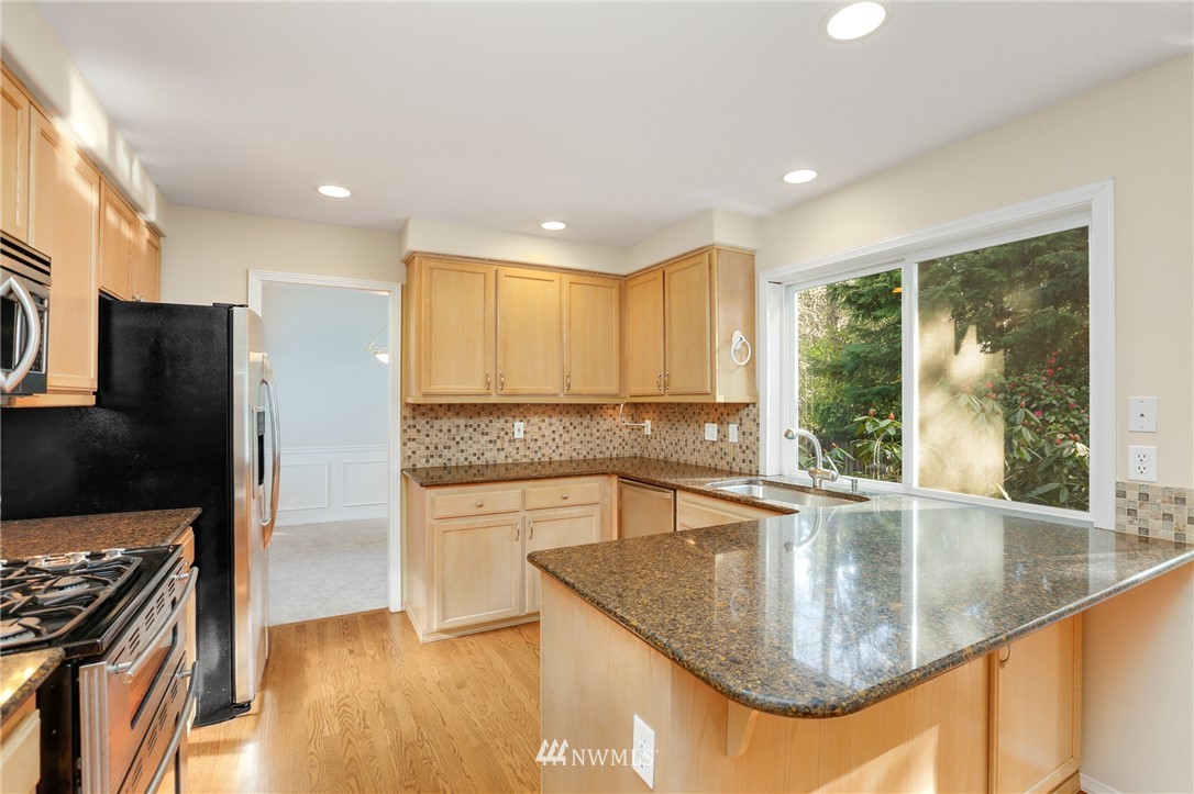19907 29th Drive Southeast Bothell, WA 98012 - Photo 3 of 25 a kitchen with stainless steel appliances granite countertop a sink a stove and a refrigerator