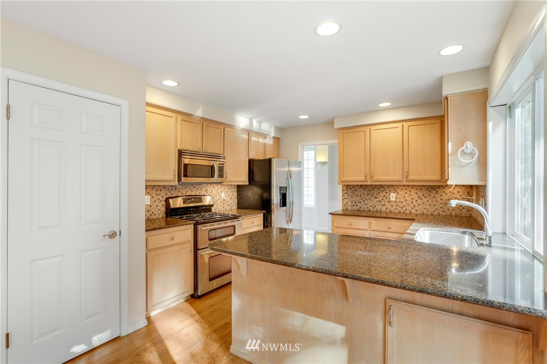19907 29th Drive Southeast Bothell, WA 98012 - Photo 5 of 25 a kitchen with stainless steel appliances granite countertop a sink a stove and a refrigerator
