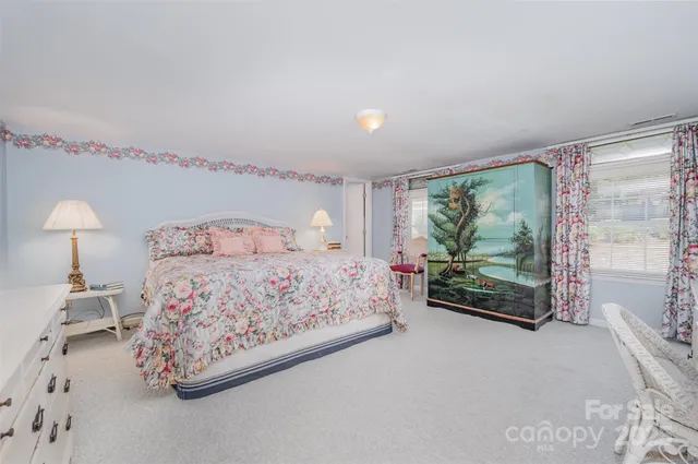 a bedroom with a bed painting and window