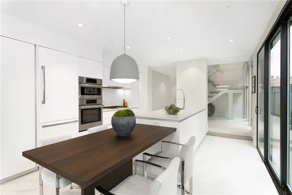 a large kitchen with kitchen island a large window in it
