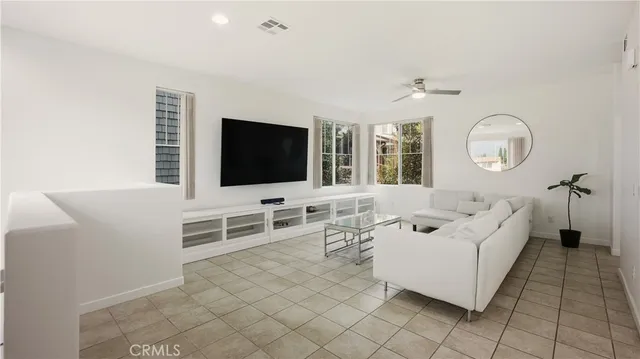 a living room with furniture a flat screen tv and a floor to ceiling window