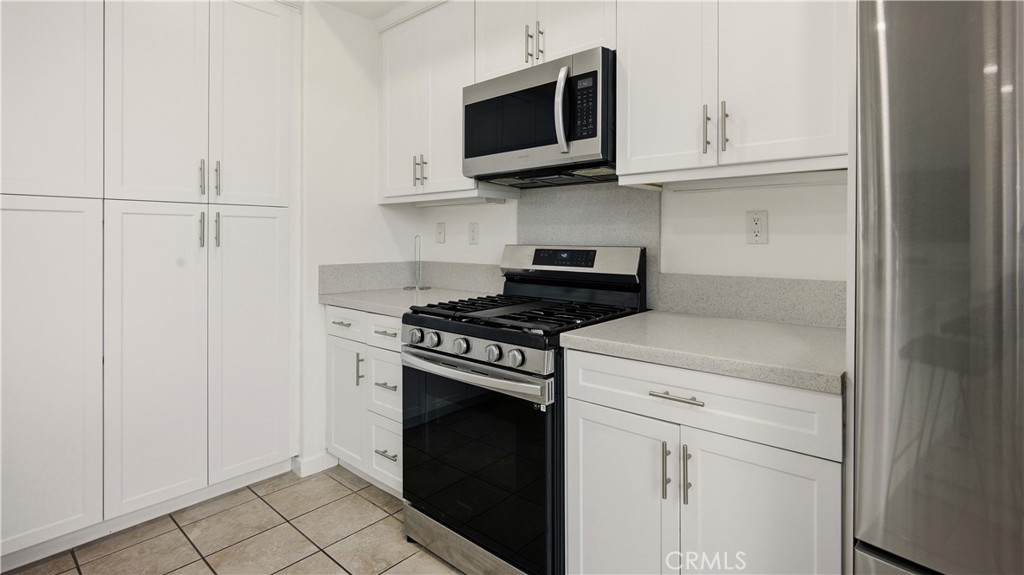 713 South Azusa Avenue, Unit A Azusa, CA 91702 - Photo 10 of 31 a kitchen with stainless steel appliances granite countertop white cabinets and a stove top oven