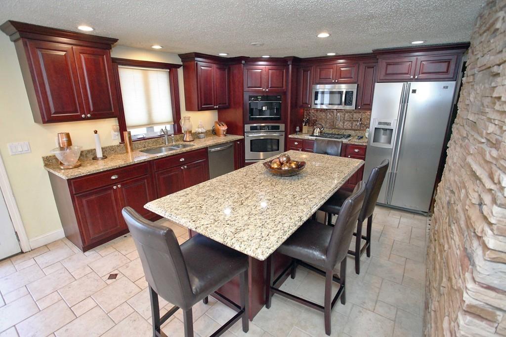 33 Gammons Road Acushnet, MA 02743 - Photo 7 of 37 a kitchen with stainless steel appliances granite countertop table chairs sink refrigerator and cabinets