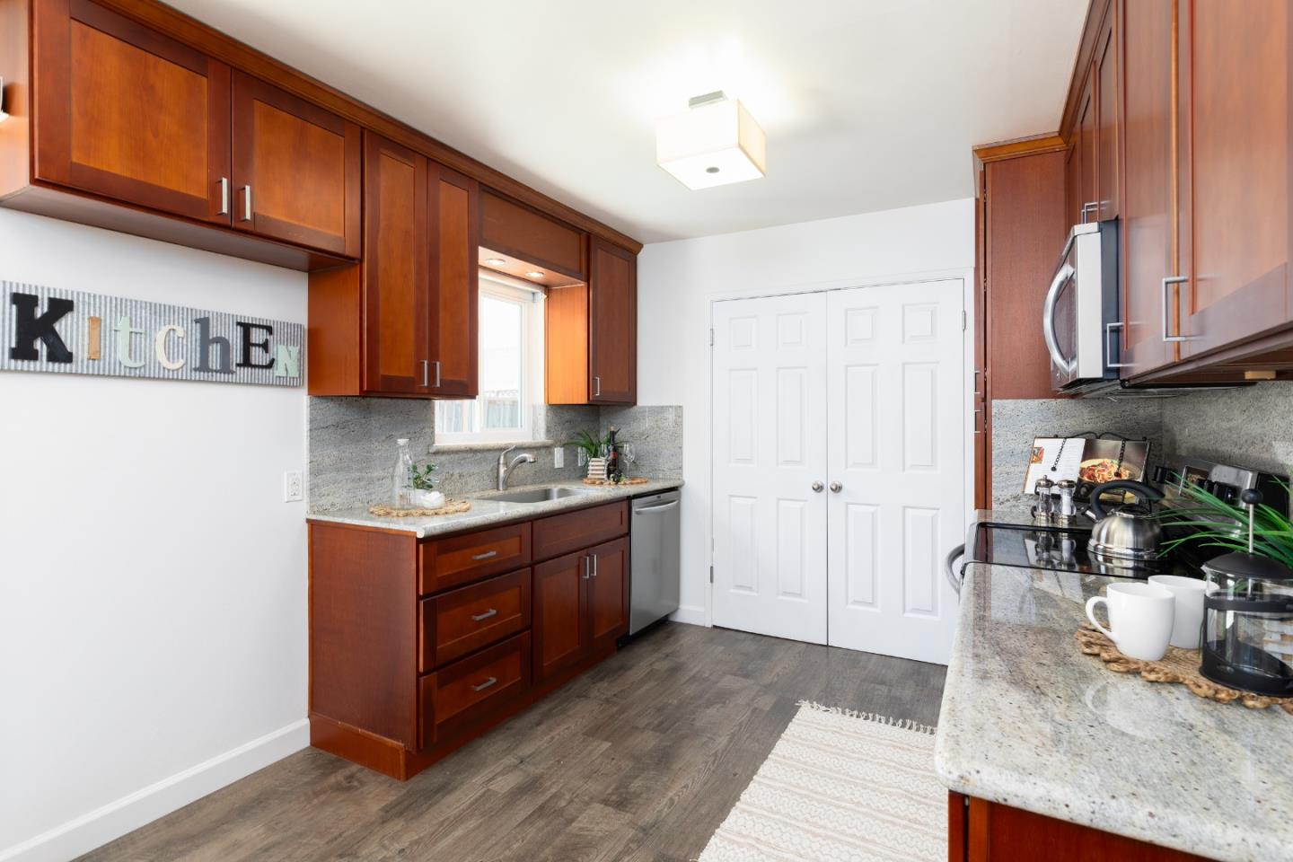 1226 Roxbury Court Santa Clara, CA 95050 - Photo 11 of 35 a kitchen with granite countertop a sink a stove and a wooden cabinets