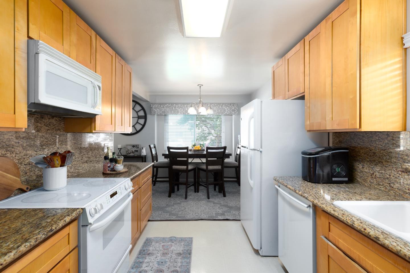 1226 Roxbury Court Santa Clara, CA 95050 - Photo 25 of 35 a kitchen with a refrigerator a stove a sink a dining table and chairs