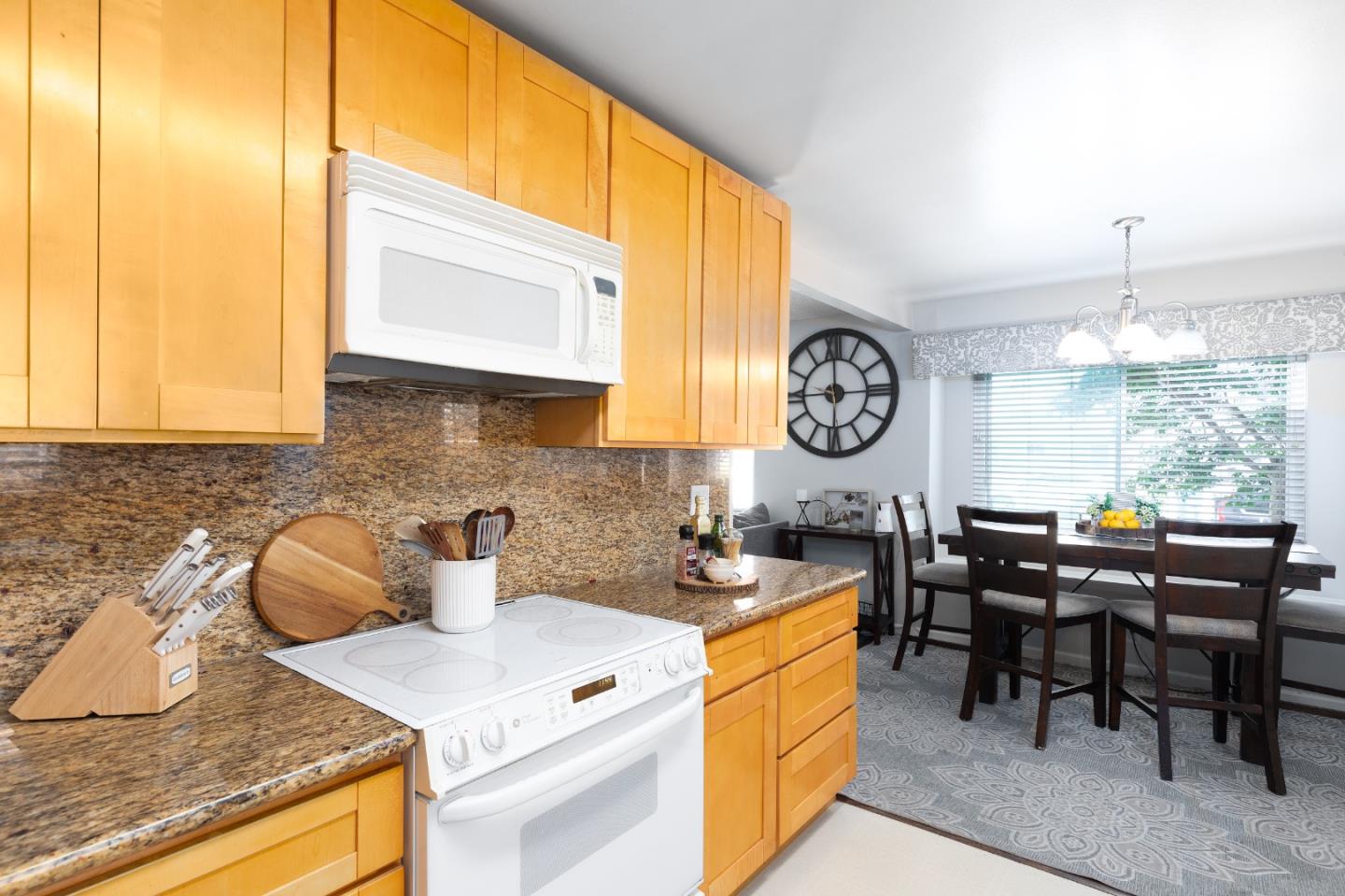 1226 Roxbury Court Santa Clara, CA 95050 - Photo 27 of 35 a kitchen with stainless steel appliances granite countertop a stove a table and chairs in it