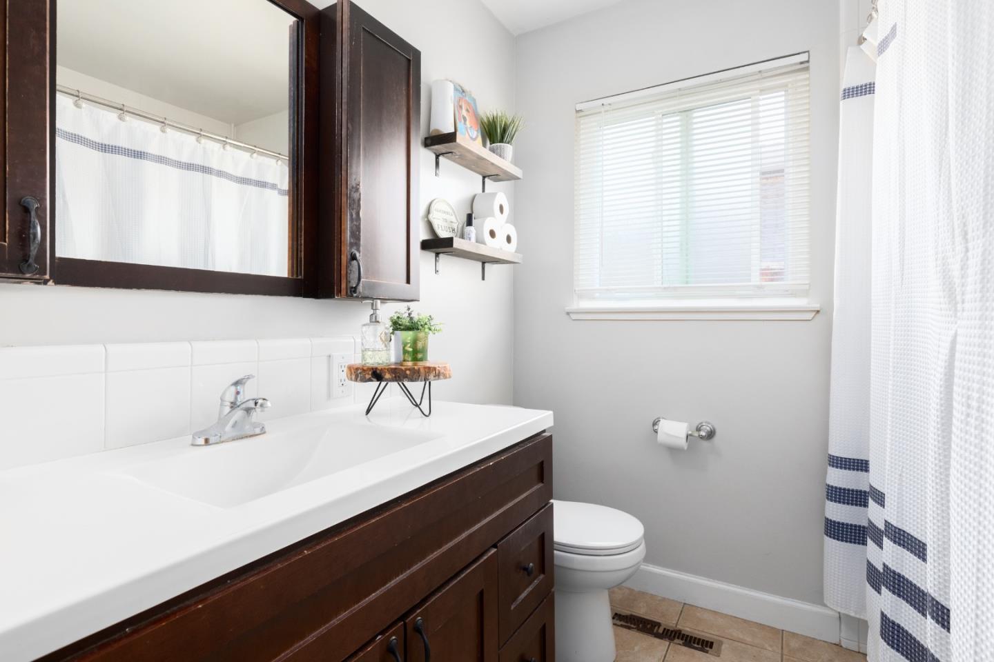 1226 Roxbury Court Santa Clara, CA 95050 - Photo 29 of 35 a bathroom with a sink a toilet and a mirror